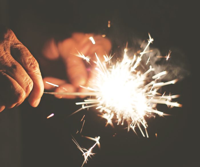 elderly hands holding sparklers